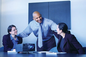 stock photo of three business people in a conference room with a projector