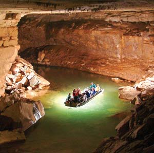 people in a boat on a river in a cave